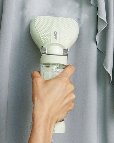 White garment steamer on fabric